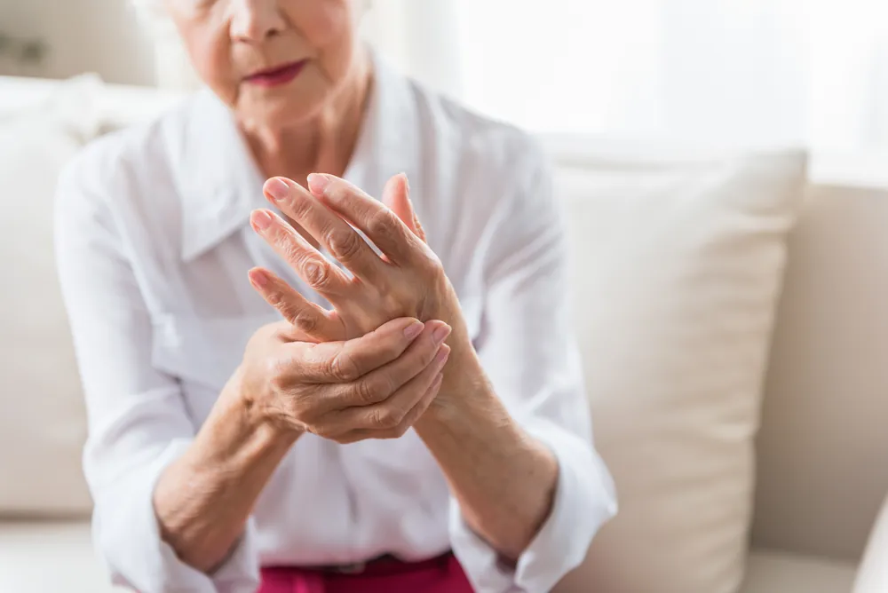 Elderly New Jersey woman struggling with nerve pain in her hand from a disc compression