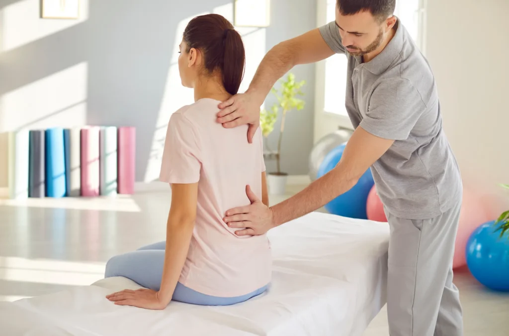 A physical therapist helping a young New Jersey woman with back pain.