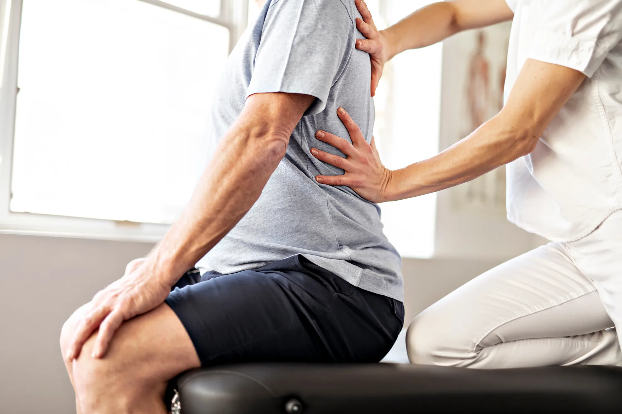 A phyiscal therapist helping a New Jersey man with lumbar spine pain.