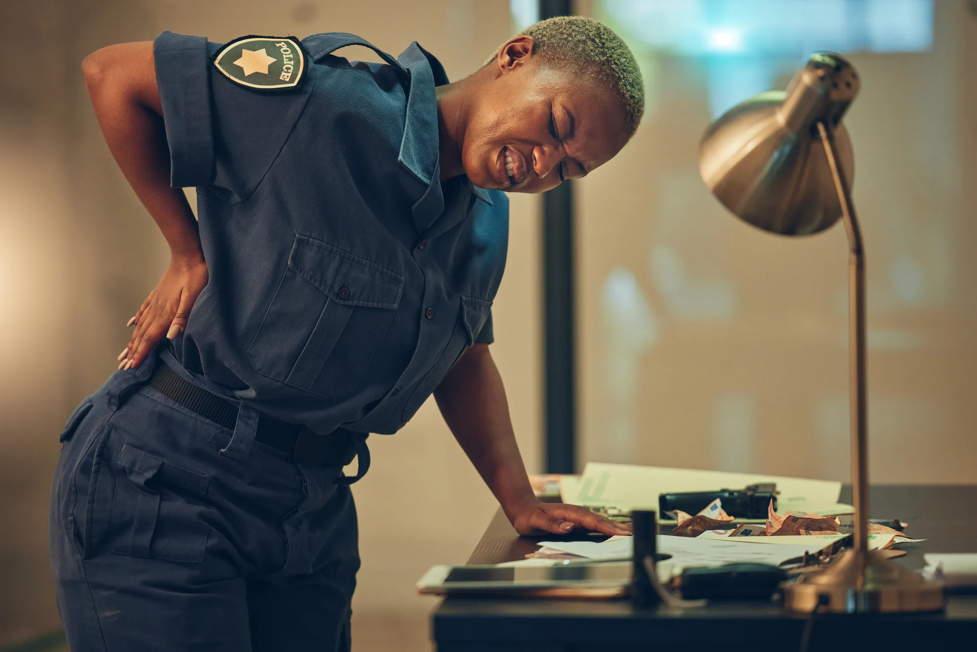 A New Jersey police officer supporting her lumbar spine after filing some paperwork