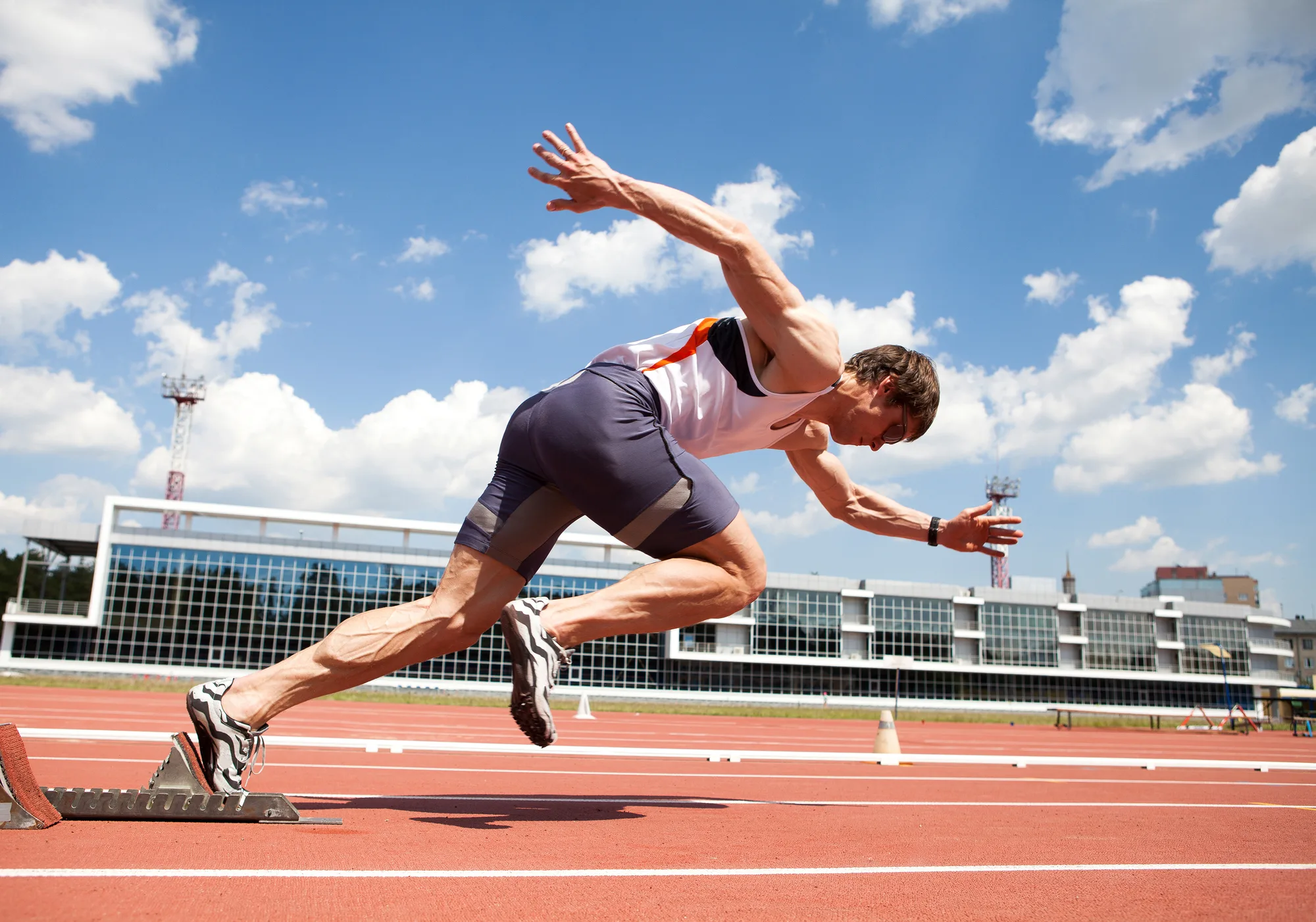 A man sprinting at full speed on a race track.
