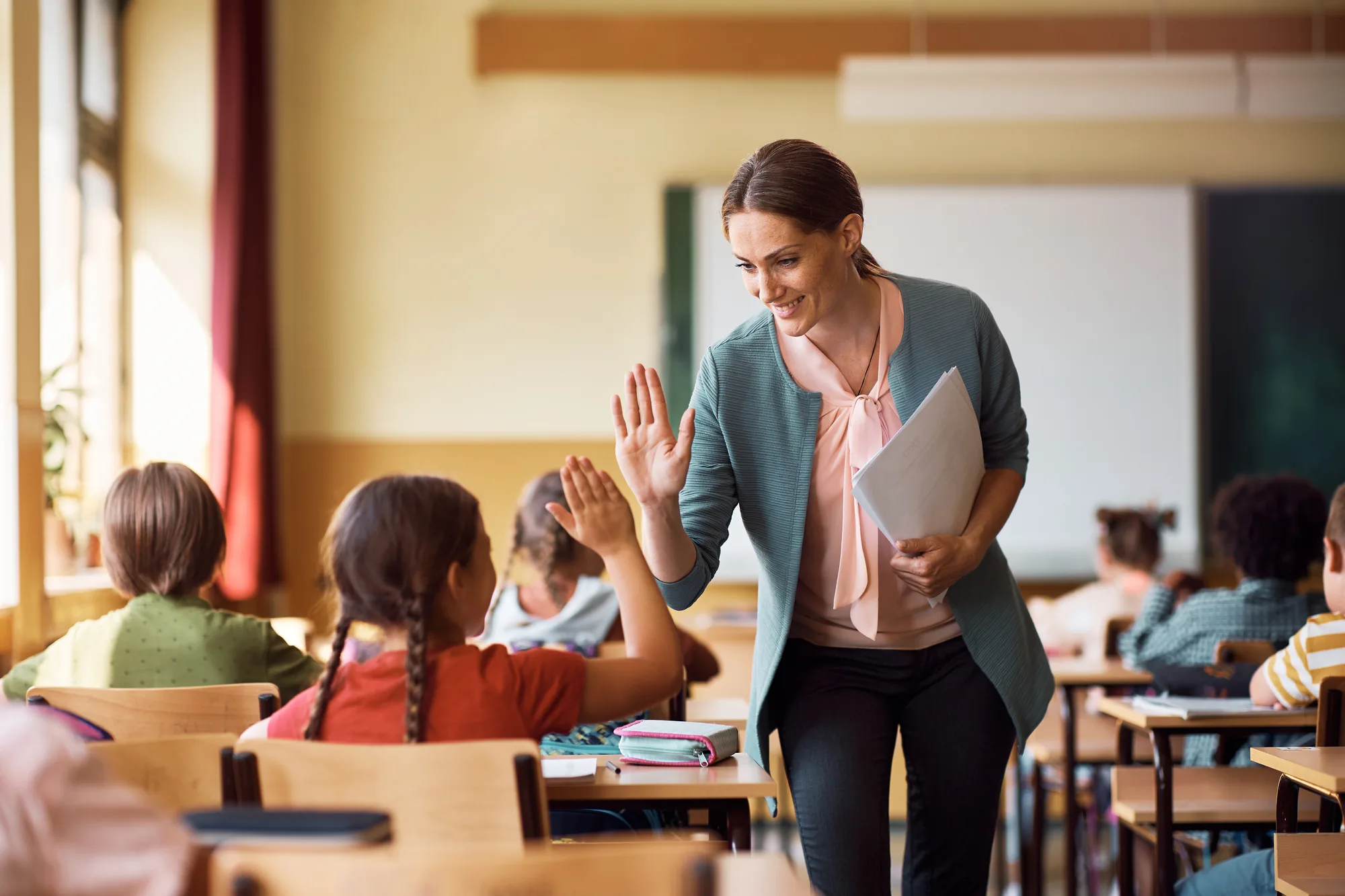 A New Jersey teacher giving one of her students a high-five after returning from Spinal Surgery.