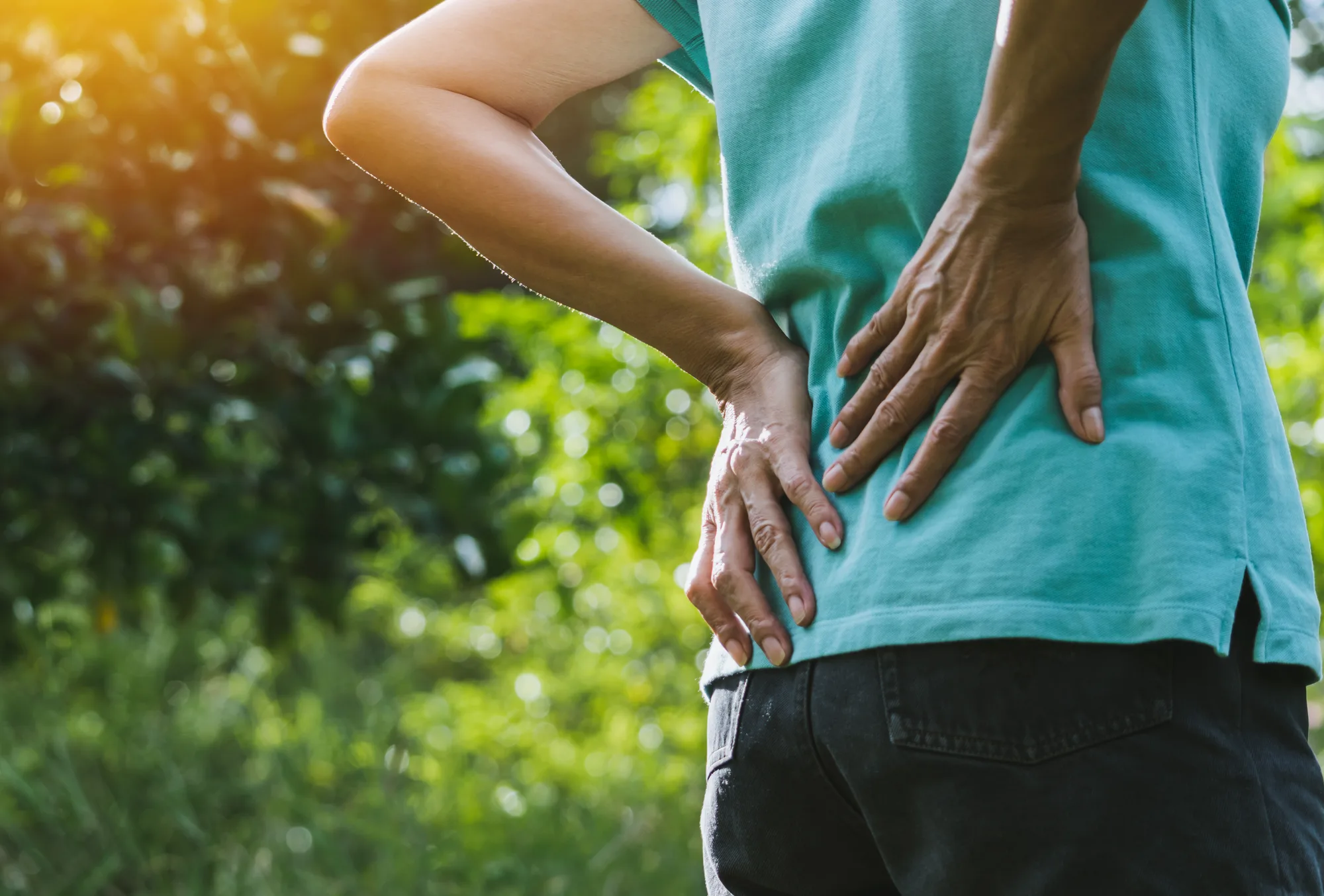 A New Jersey woman holding her back after a disc herniation.